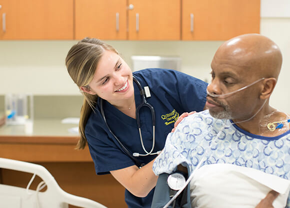 A nursing student works with a patient.