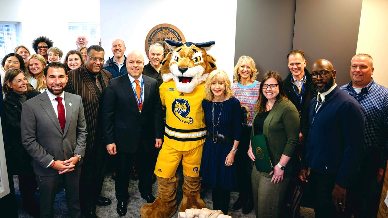 People stand with Bobcat Mascot in newly renovated public safety building
