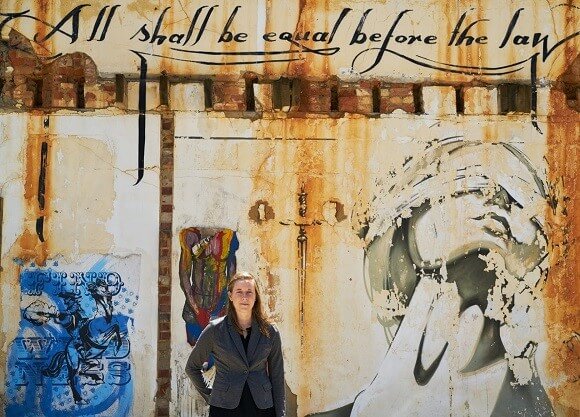 Altimier stands in front of a mural near courts in Cape Town.