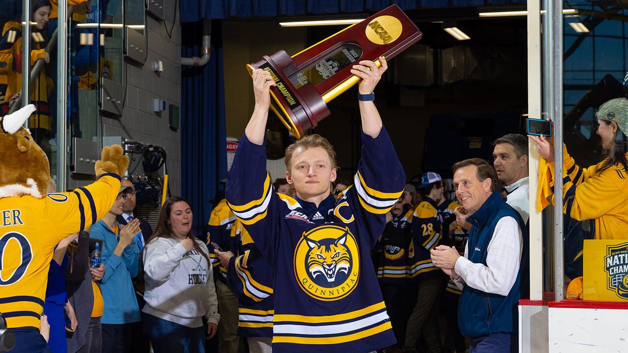 Captain of Quinnipiac mens ice hockey team Zach Metsa holding NCAA 2023 National Championship trophy