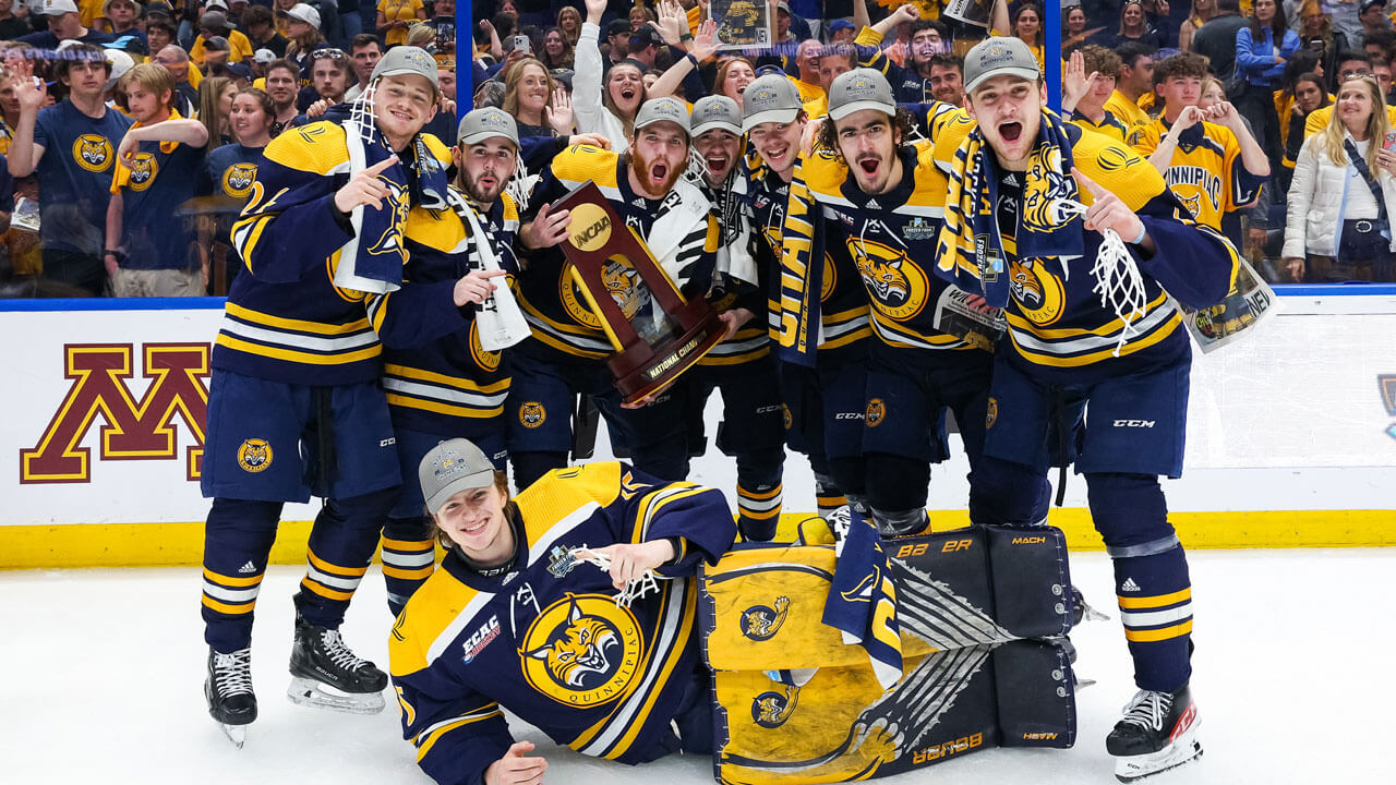 Ice hockey team posing and cheering with trophy