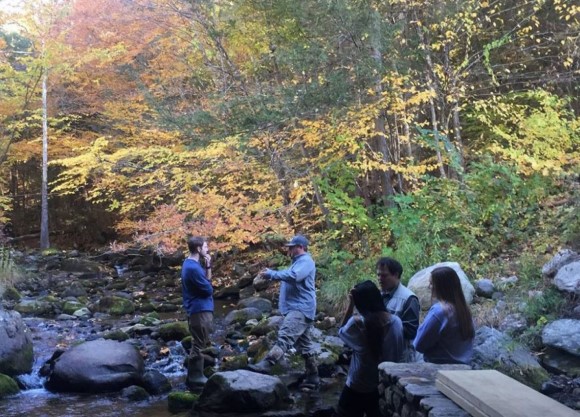 Journalism professor and students speak to a reporter from WTNH-TV at a stream