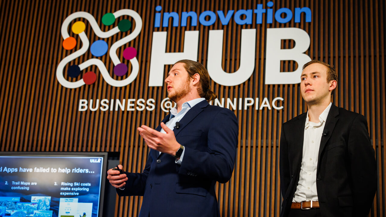 Two students present their pitch at the 2022 People's United Center for Innovation and Entrepreneurship Pitch Competition.