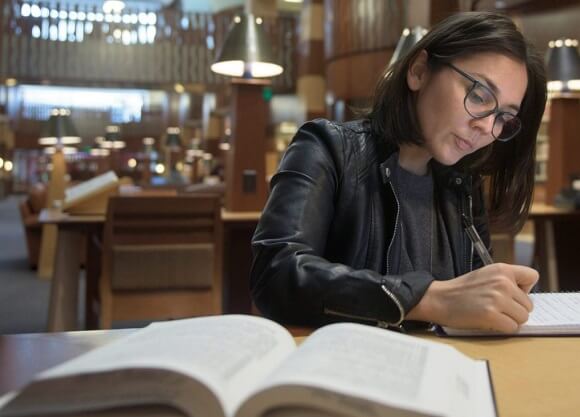 Law student Denia Perez writes in her notebook in the law library