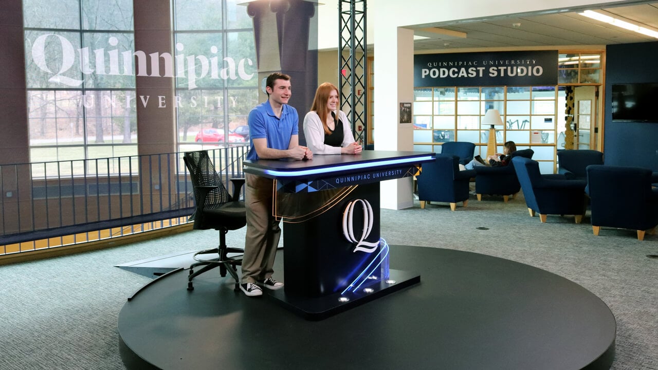 Communications students standing at the podium of the open-air studio on the Mount Carmel Campus.