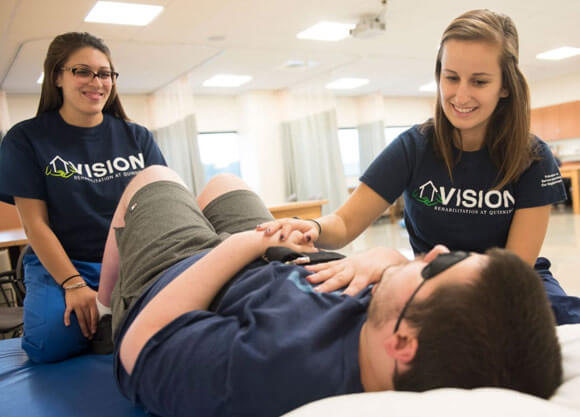 Physical therapy students Alissa Rocco, left, and Kristianna Giannico work with patient Mike Mingrone at the VISION clinic, a weekly, student-run, pro-bono clinic on our North Haven Campus.