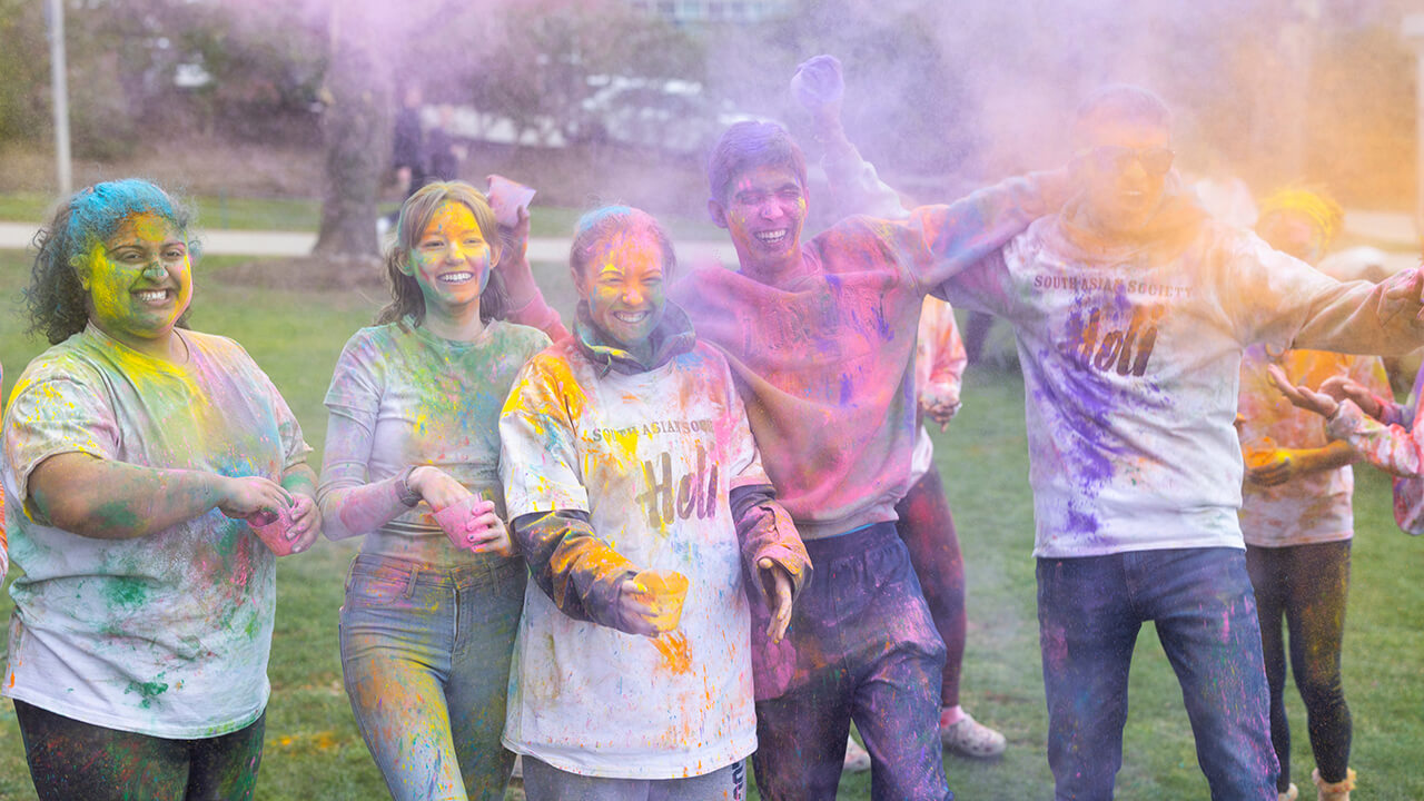 Students smiling and cheering during Holi celebration