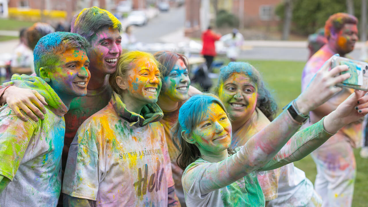Group of students taking selfie together at Holi celebration