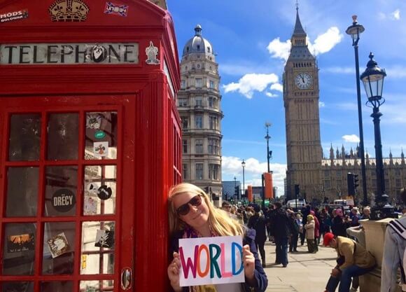 Jacqueline Waite poses next to a red telephone booth with Big Ben in the background in London