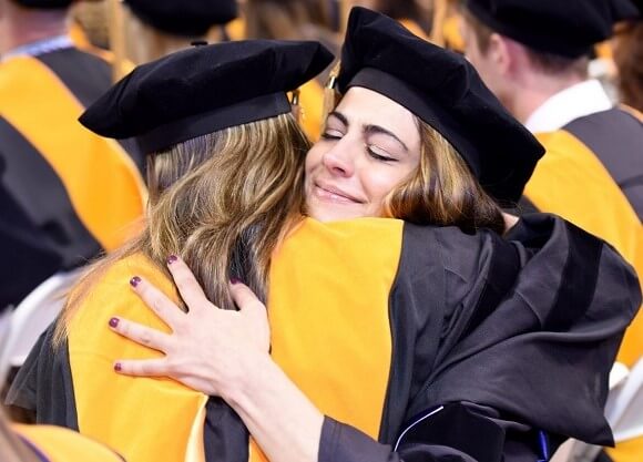 Two student hugging at graduation