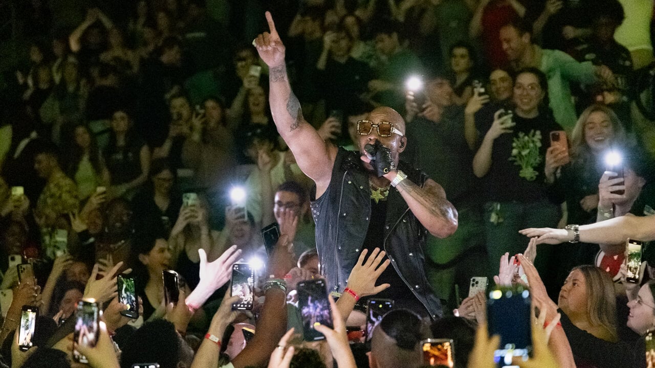 Flo Rida signs in the crowd surrounded by Quinnipiac students