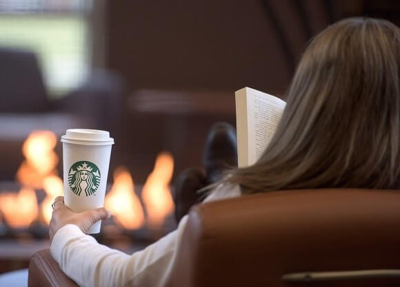 Quinnipiac sophomore Alexandra Ford drinks Starbucks coffee as she reads.