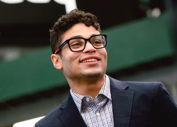 Jacob Nunez smiling in glasses and a suit