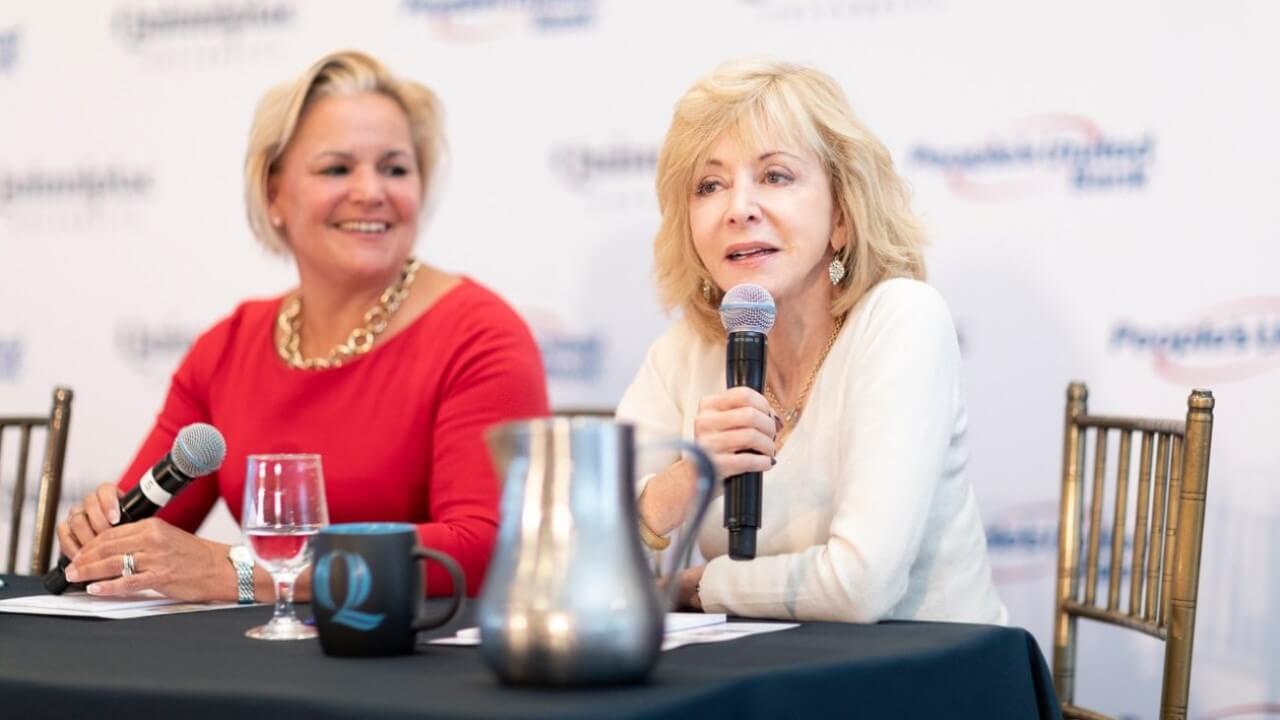 Sara Longobardi and Judy Olian sit at a table talking.