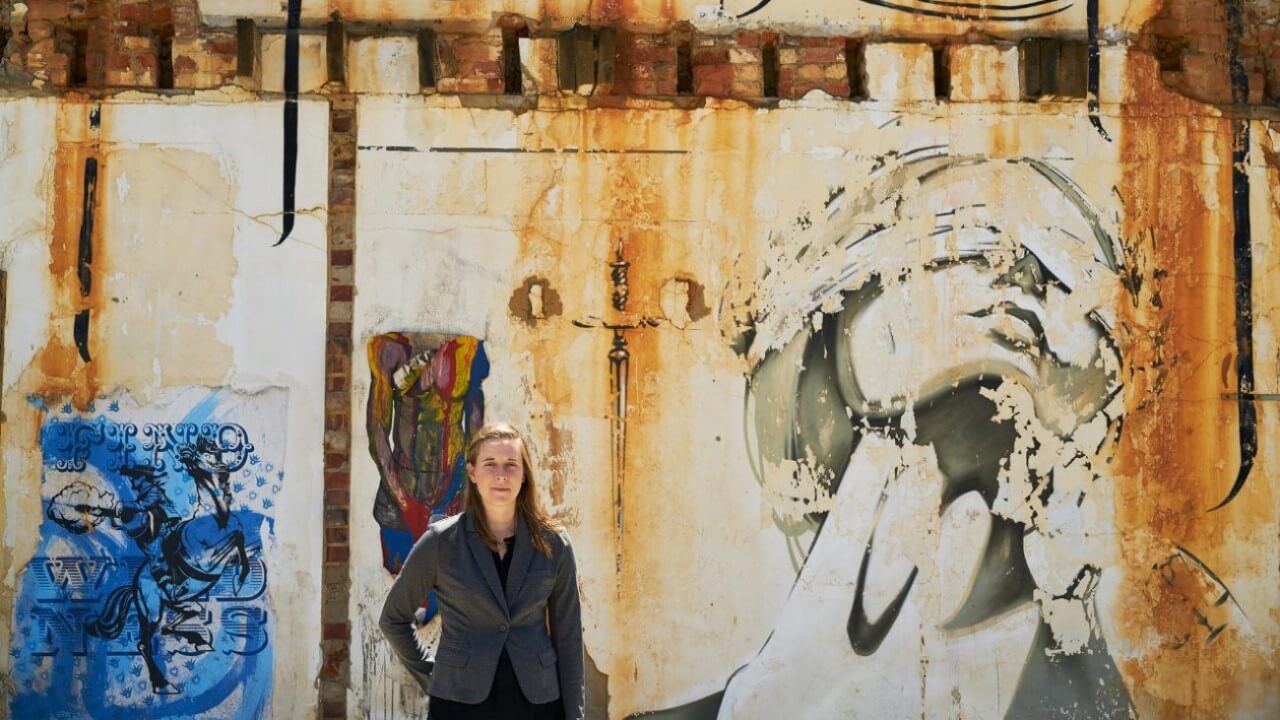 Altimier stands in front of a mural near courts in Cape Town.