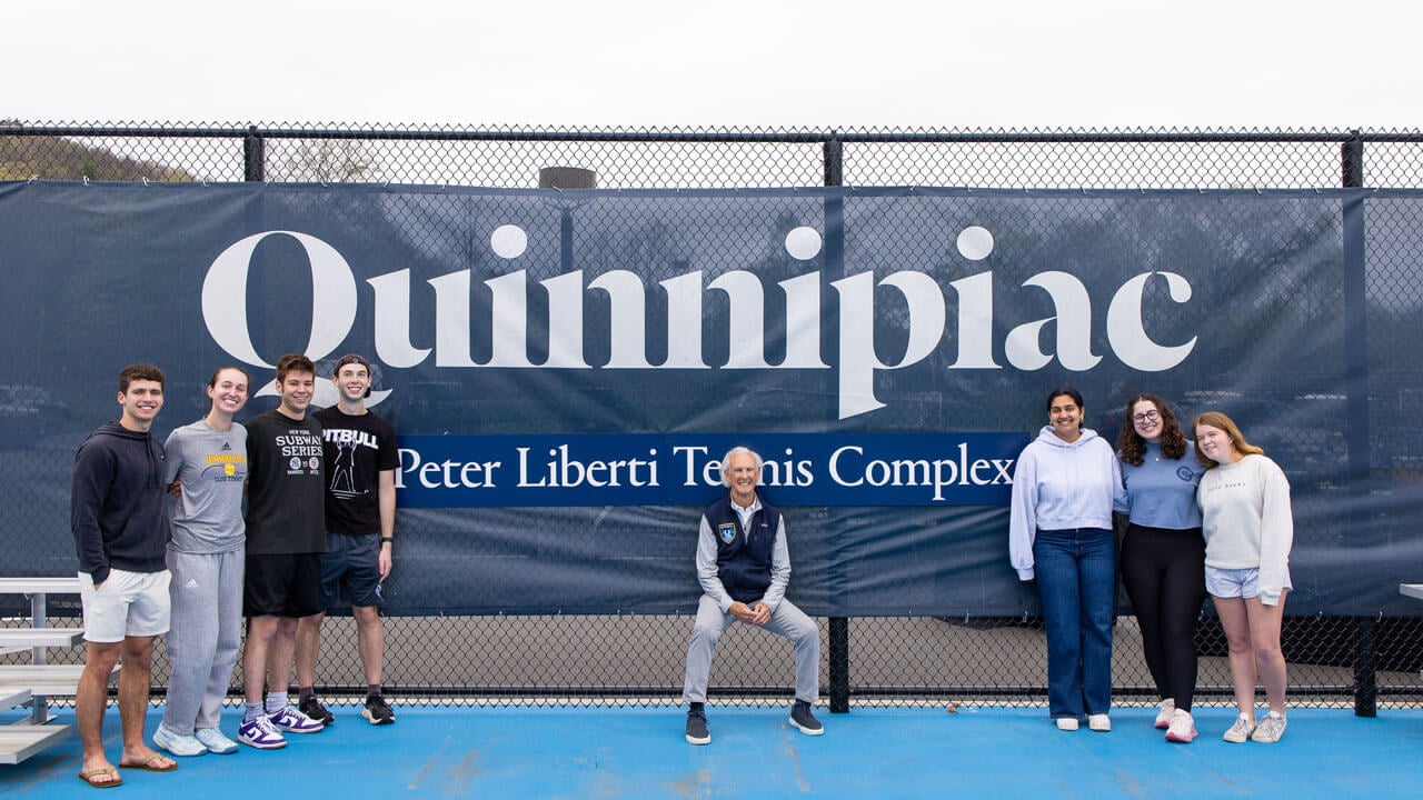 Peter Liberti smiles with student athletes in front of the new Peter Liberti tennis complex