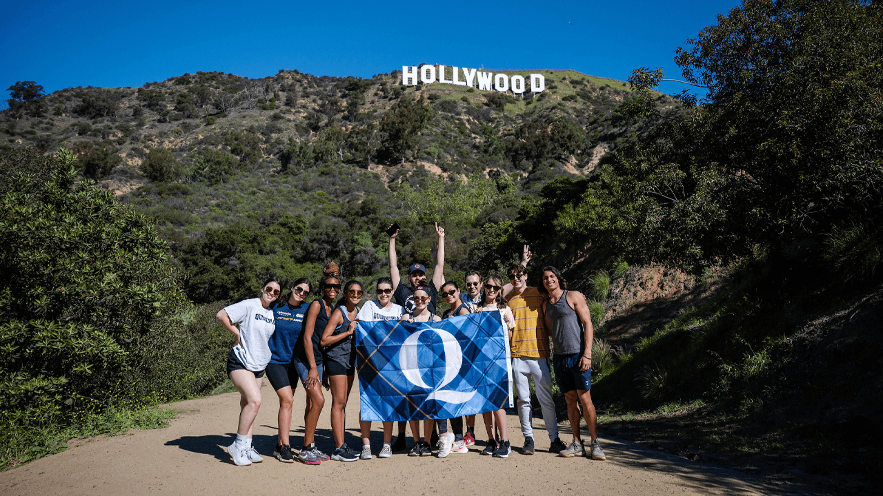 Students hold QU flag in front of Hollywood sign