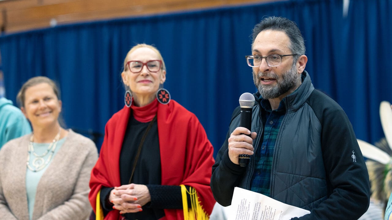 A speaker talks to the crowd at the Dancing in the Shadow of Sleeping Giant Powwow
