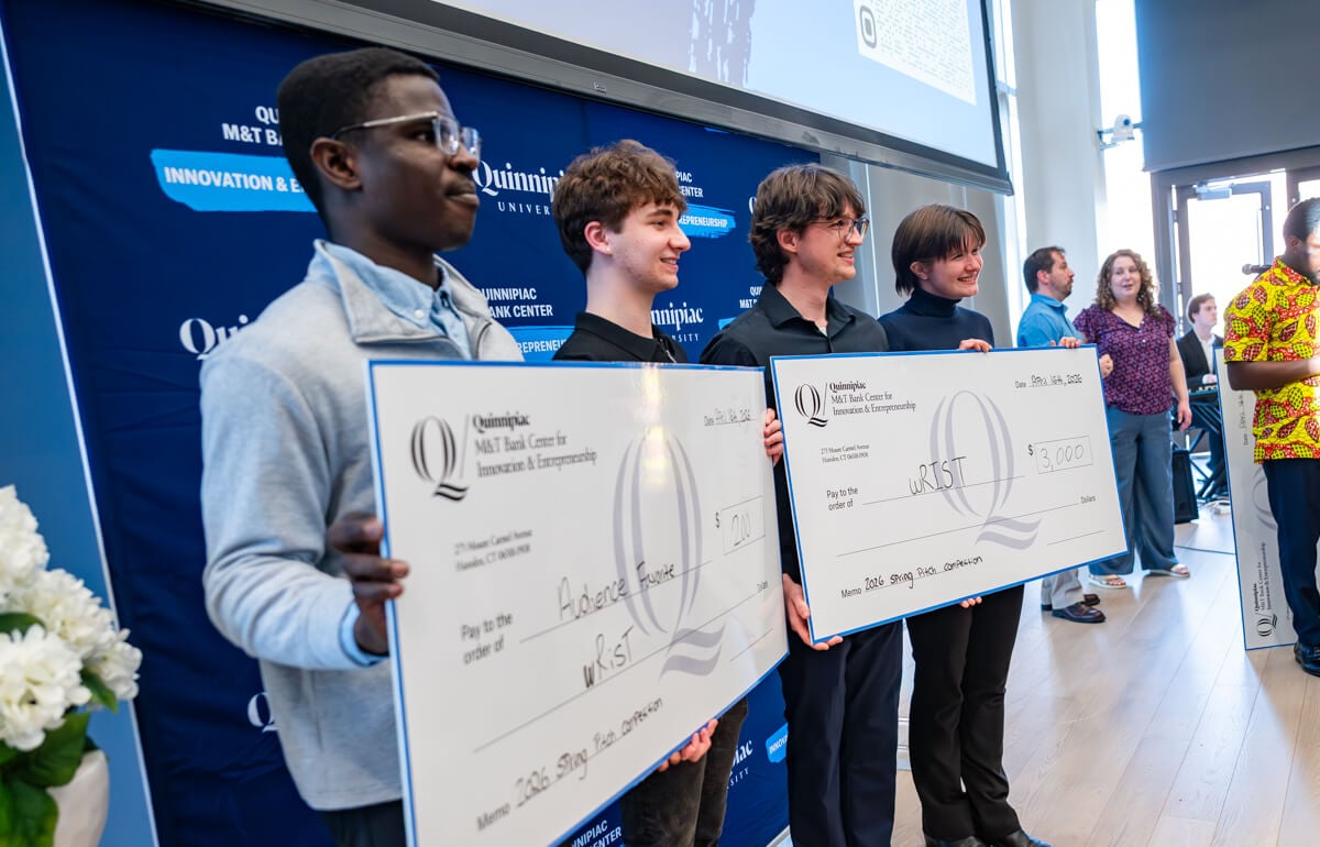 Winning student hold their check