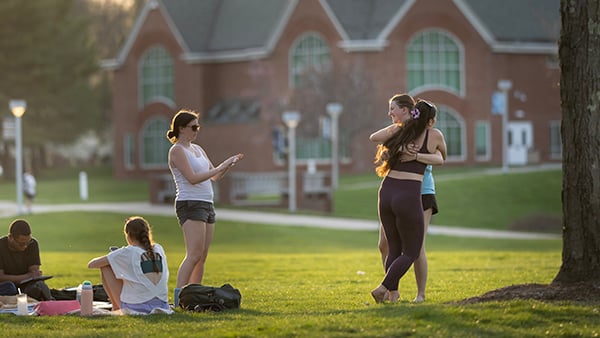 Students embracing and walking along the Quad