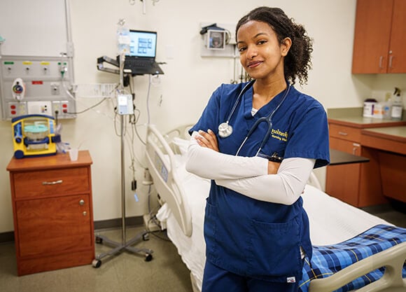 Nursing student Edna Yilma, hands crossed on chest looking at camera.
