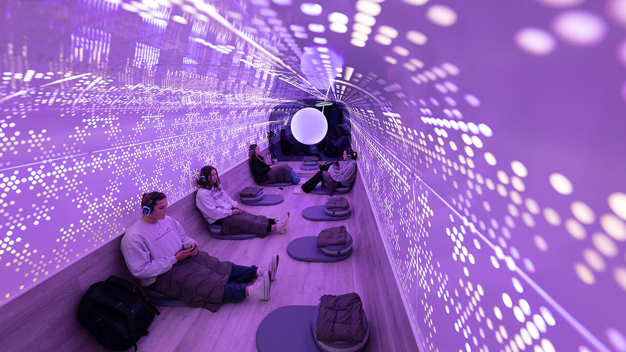 Students sitting inside a meditation bus with purple fluorescent lighting