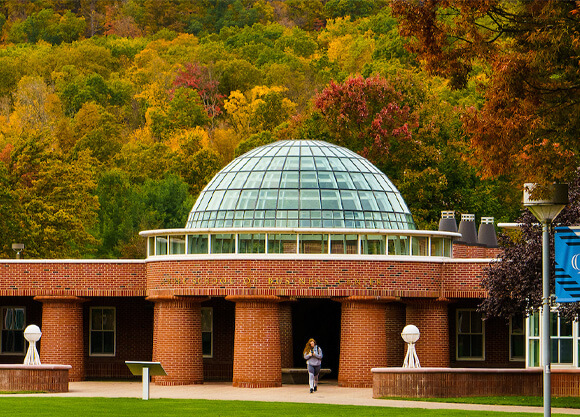 Quinnipiac's School of Business in front of trees filled with colorful fall leaves.