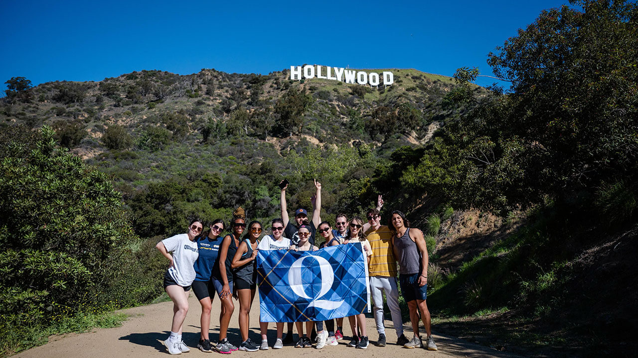 Students take a group photo in front of the Hollywood sign