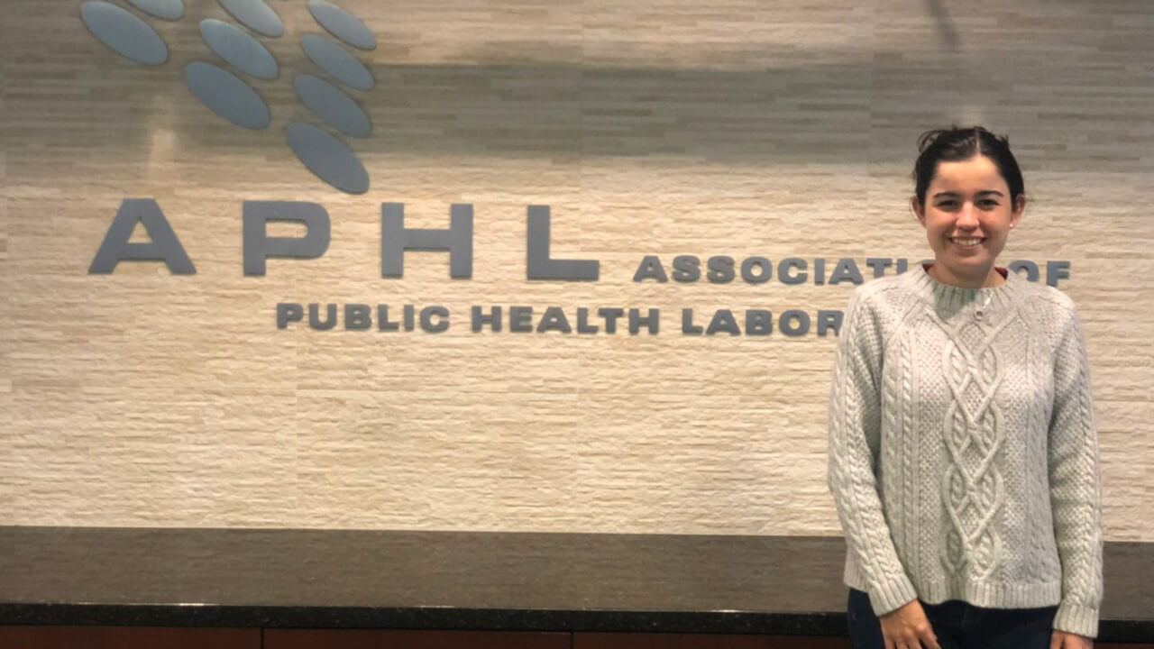 Danielle Marcone in front of an APHL sign indoors