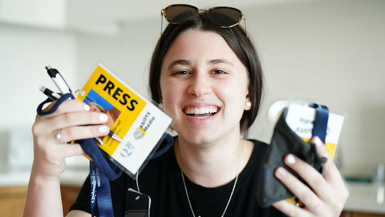 Ephemia Nicolakis holding press passes