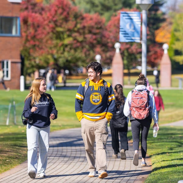 Students walk on a path across the Quinnipiac quad on a fall day