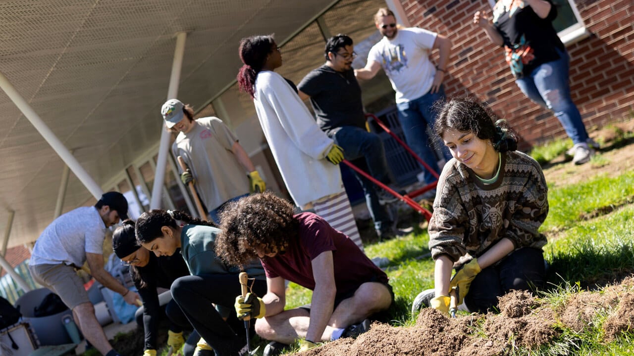 Students outside using gardening tools