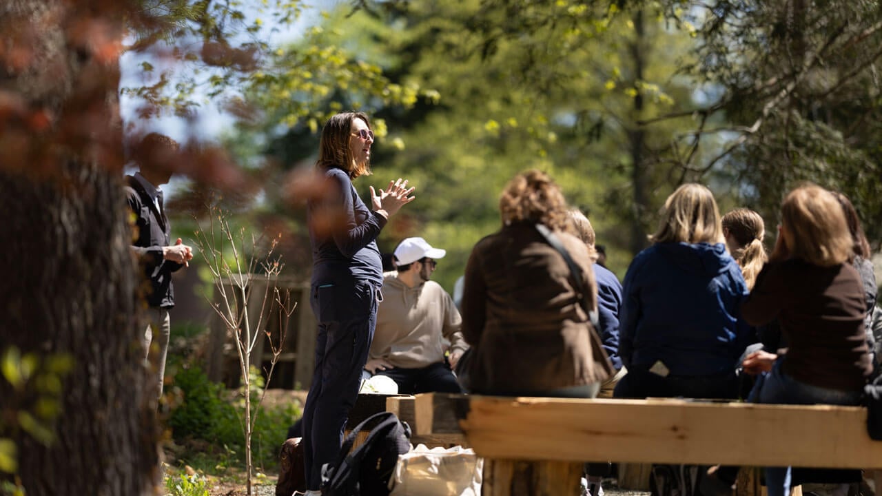 A professor lectures to her students as part of an outdoor classroom