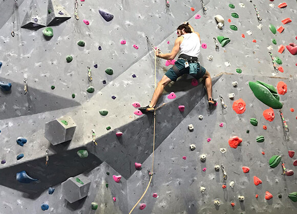 A student rock climbs