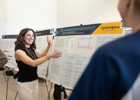 Emily Whitters presenting her poster at Illuminate: The Quinnipiac Student Expo.