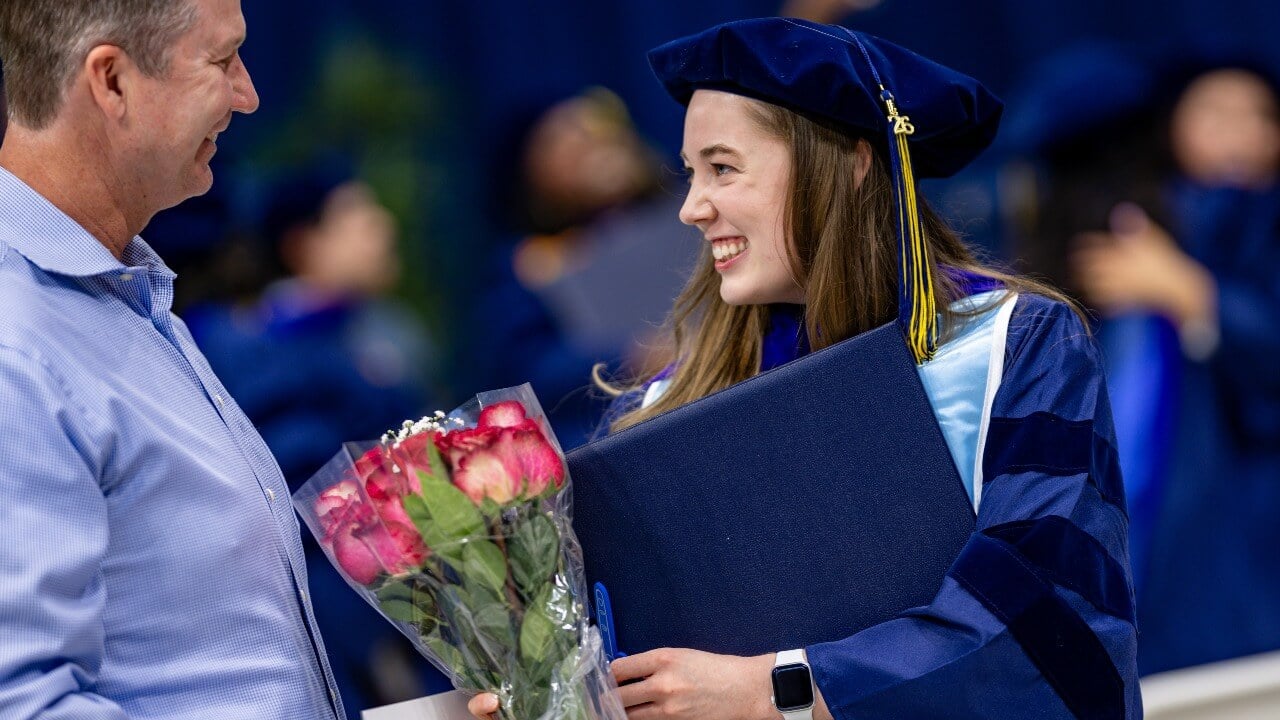 Graduate receives flowers from loved one after commencement