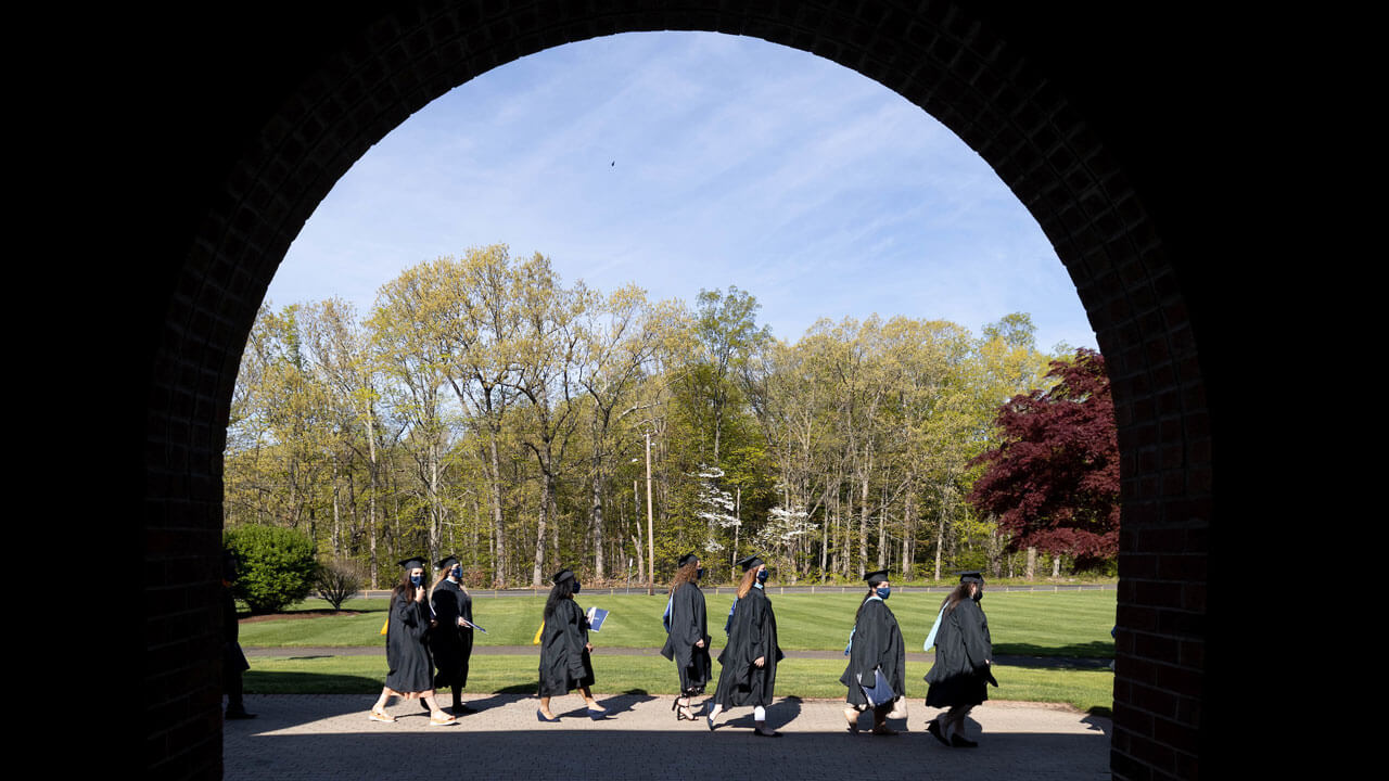 Students walking under arc to get ready for commencement