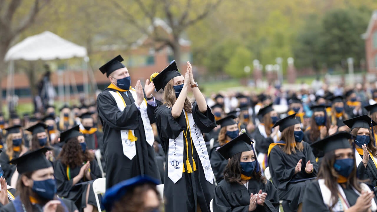 Students stand up and clap during ceremony