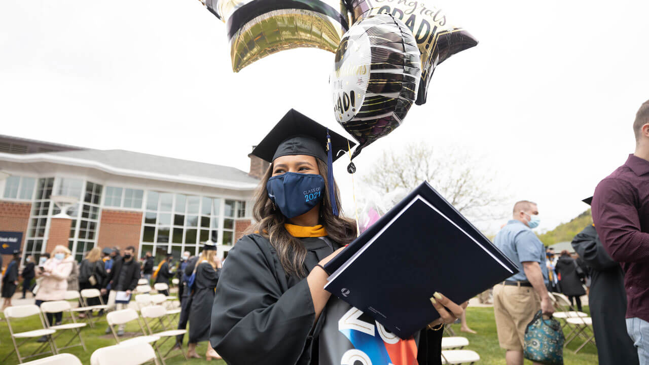 Student celebrates her receiving degree with smile and balloons