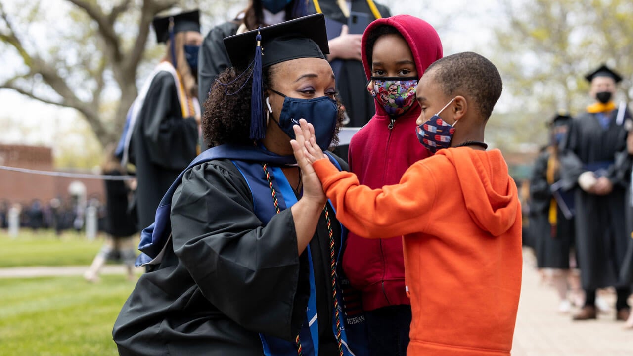 Graduate student high fiving her two kids