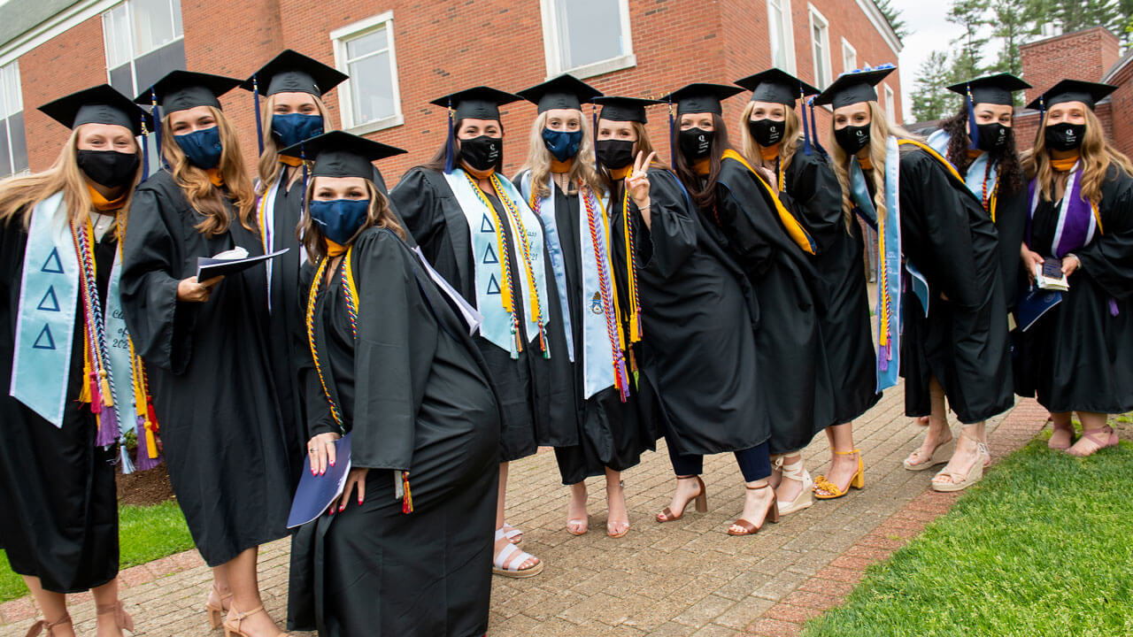 A dozen graduates pose for a photo during Commencement line up