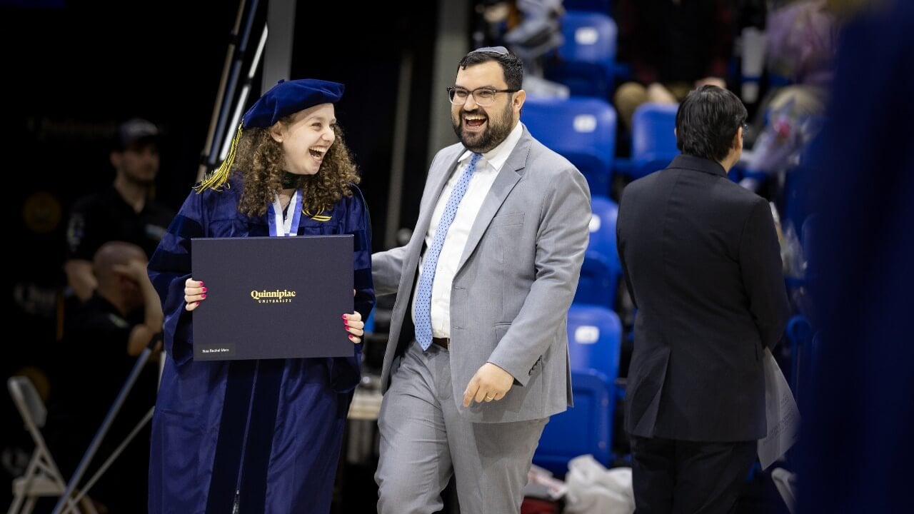 Graduate and guest smiling together