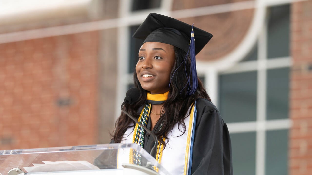Olamide Gbotosho speaks at the podium during Commencement