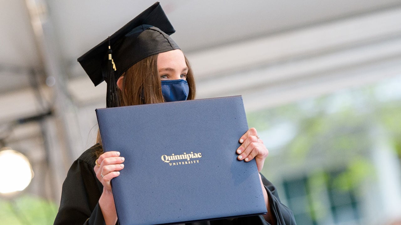 Kailee Heffler holds up her diploma cover in celebration