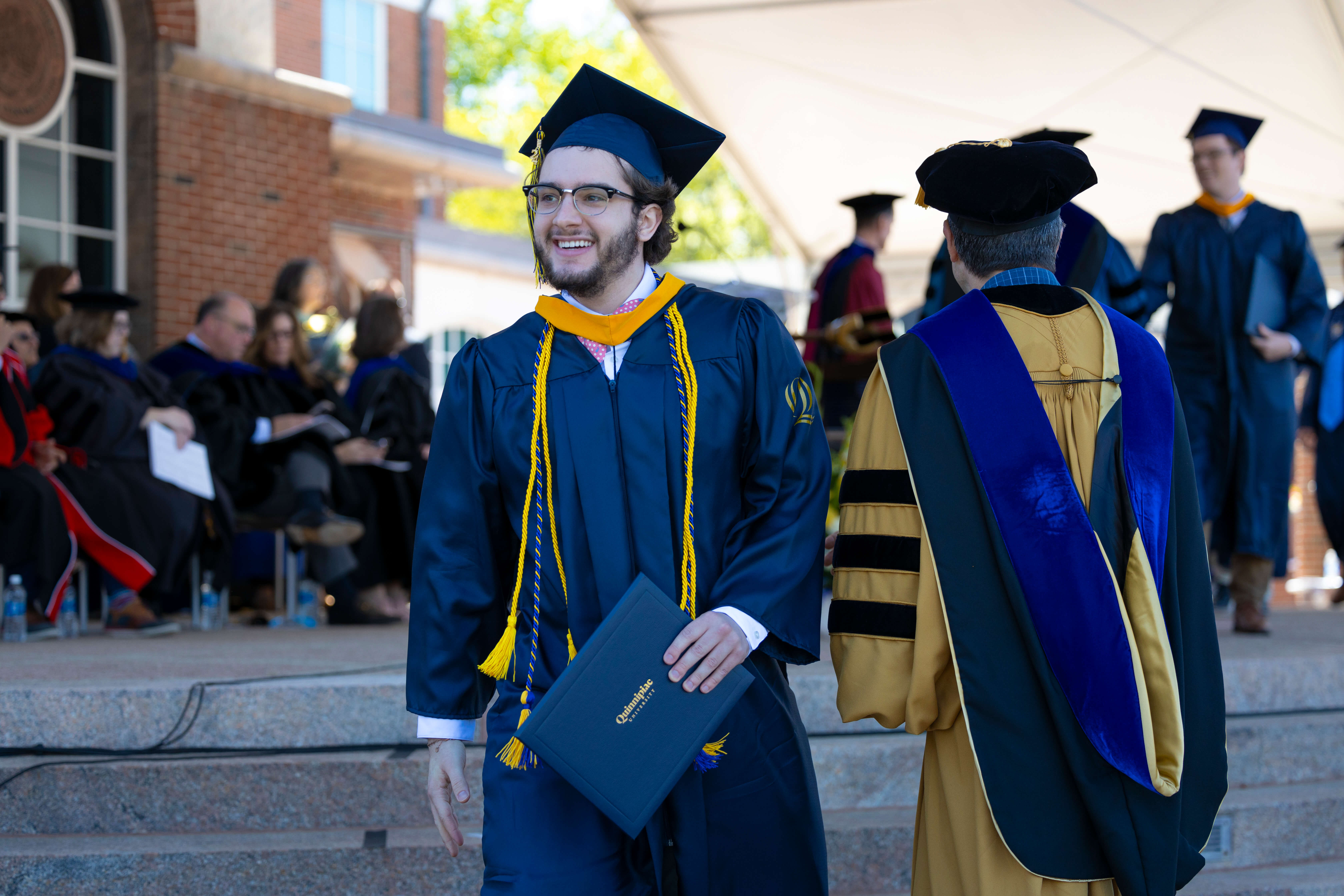 Smiling graduate walking after receiving his diploma