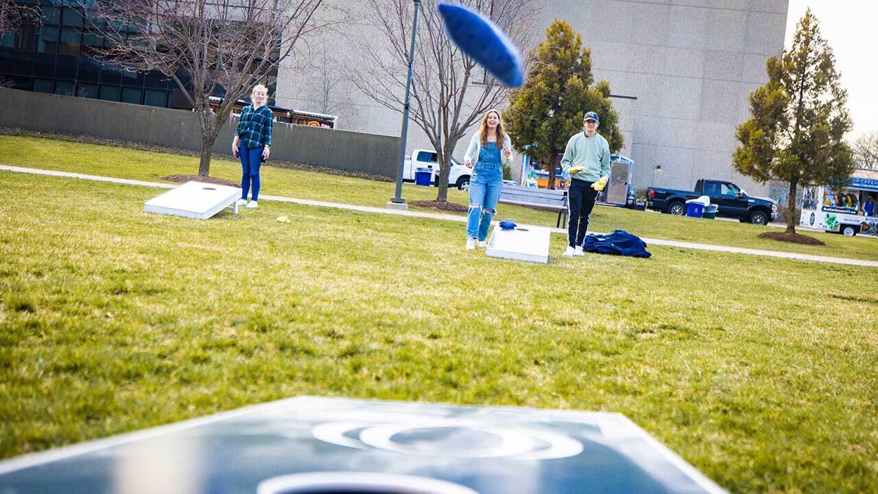 Students play corn hole on the law school lawn