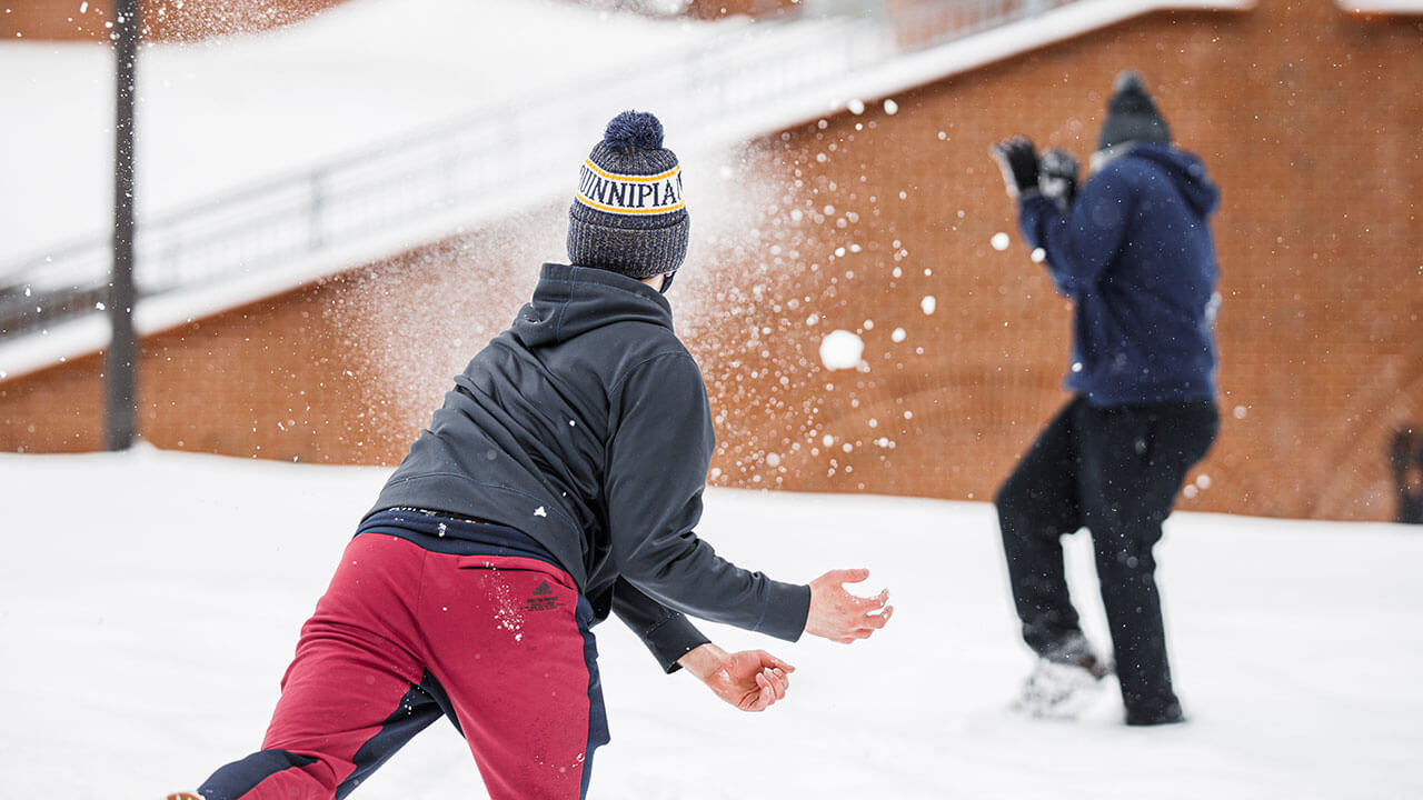 Students have a snowball fight outside