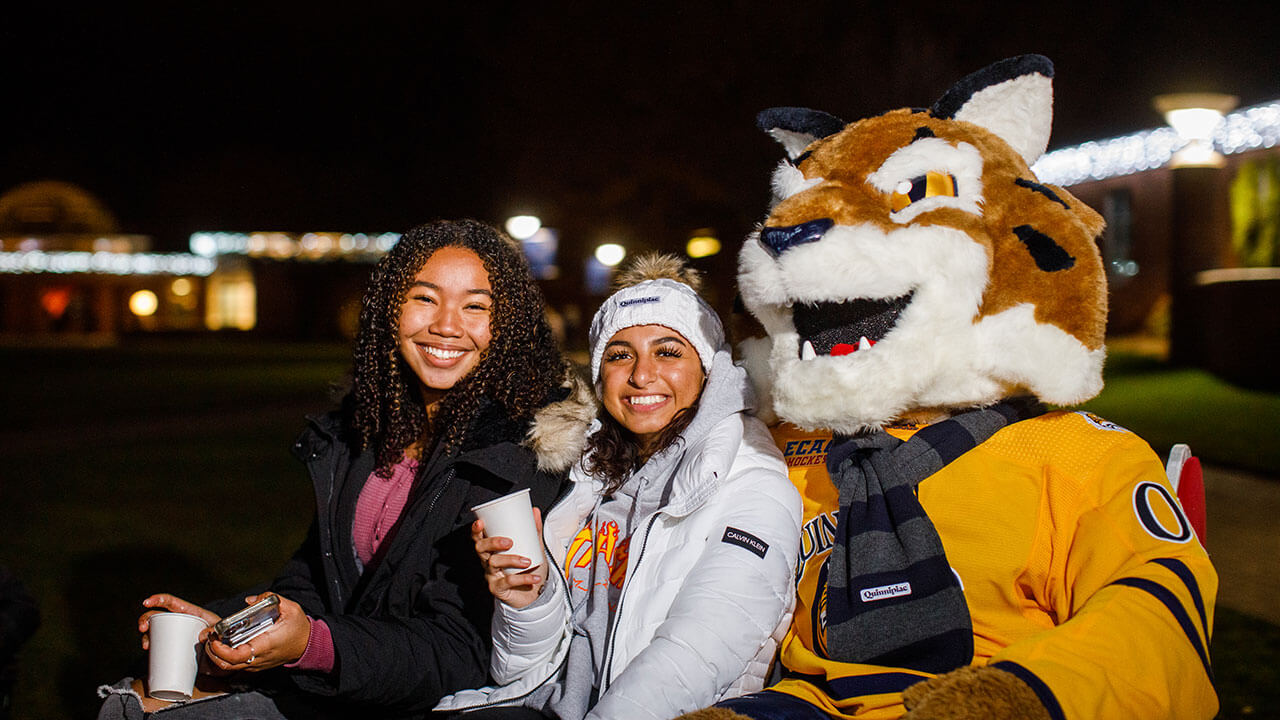 Students take a picture with Boomer on a sled