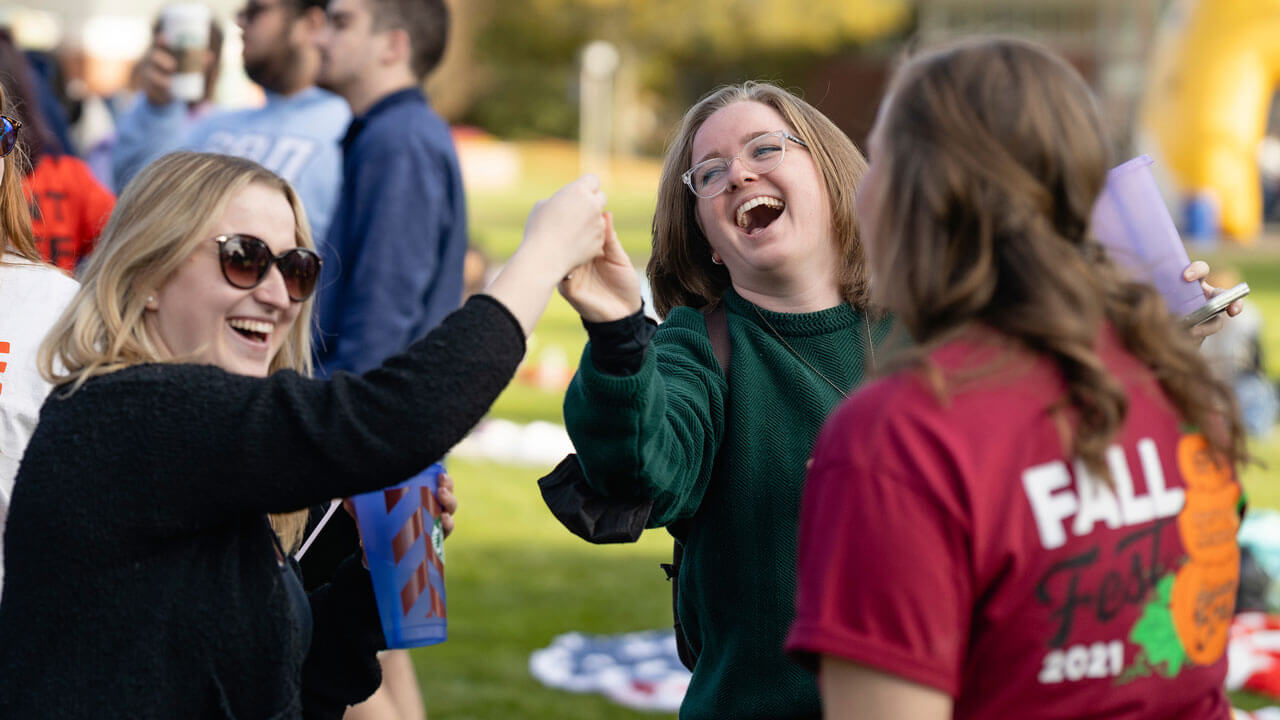 Students laughing at Fall Fest on the quad