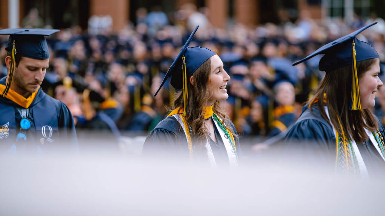 Beaming with pride, a 2024 Health Sciences graduate student walks with their peers to their seats.